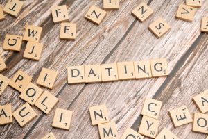 A closeup of a Scrabble game board that shows the letters spelled out - "DATING".